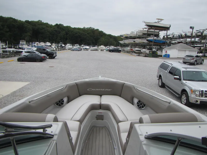 Slide: The Image of 2023 Crownline 270 SS boat interior at marina with parked cars and boats. - 10
