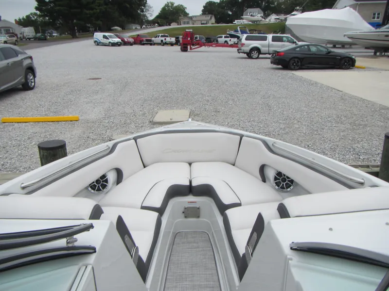 Slide: The Image of 2023 Crownline 270 SS boat interior with plush seating at a marina. - 6