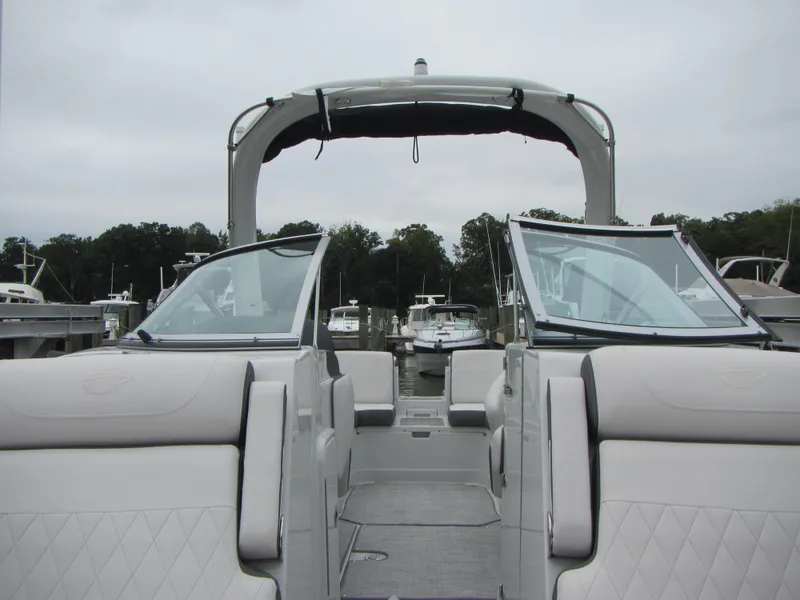 Slide: The Image of 2023 Crownline 270 SS boat with open cockpit and sleek design at a marina. - 7