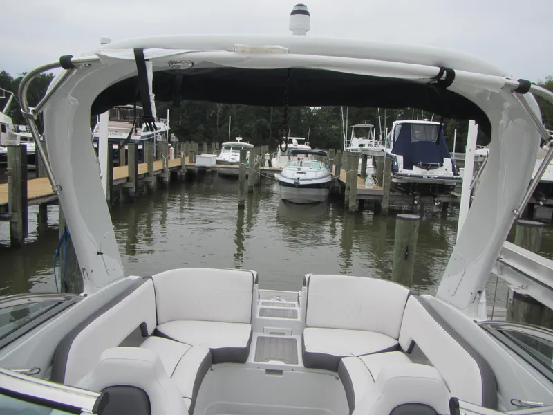 Slide: The Image of 2023 Crownline 270 SS boat with spacious seating, docked in a marina. - 8