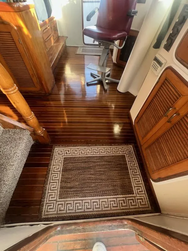 Slide: The Image of 1987 Marine Trader 62 Med Yacht interior with polished wooden floors and a captain's chair. - 16