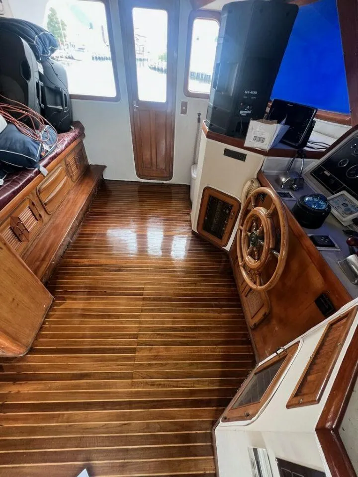Slide: The Image of 1987 Marine Trader 62 Med Yacht interior with polished wooden flooring and steering wheel. - 36