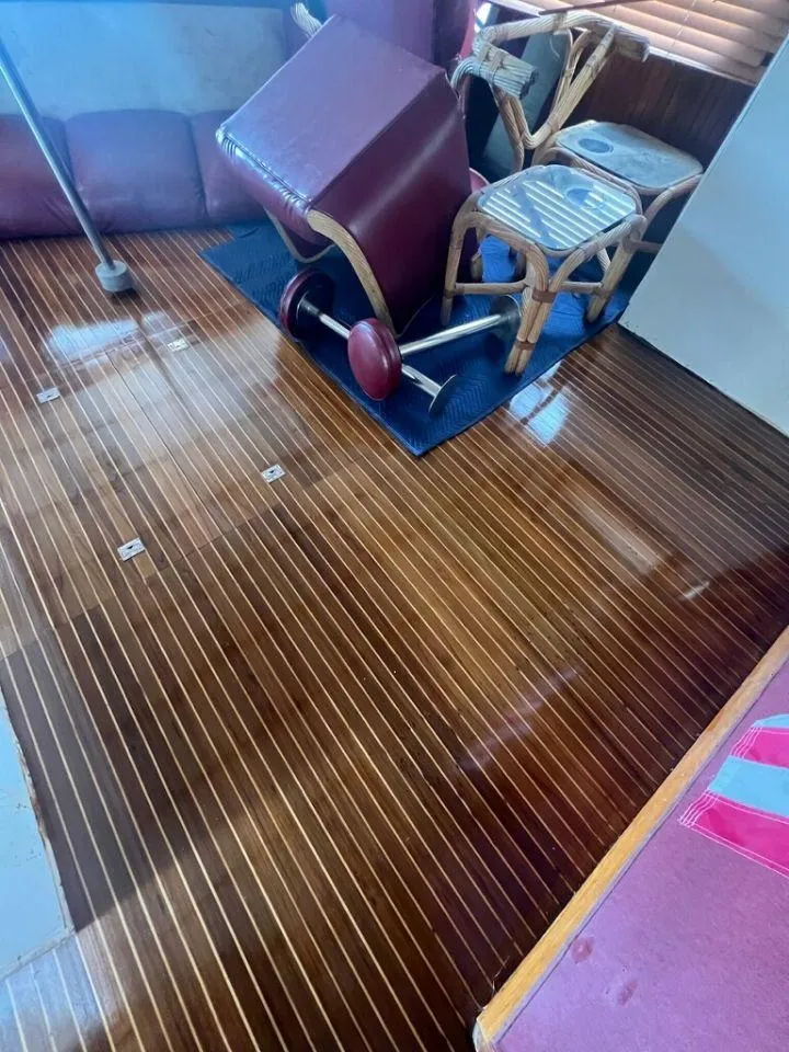 Slide: The Image of 1987 Marine Trader 62 Med Yacht interior with polished wooden floor and overturned furniture. - 38