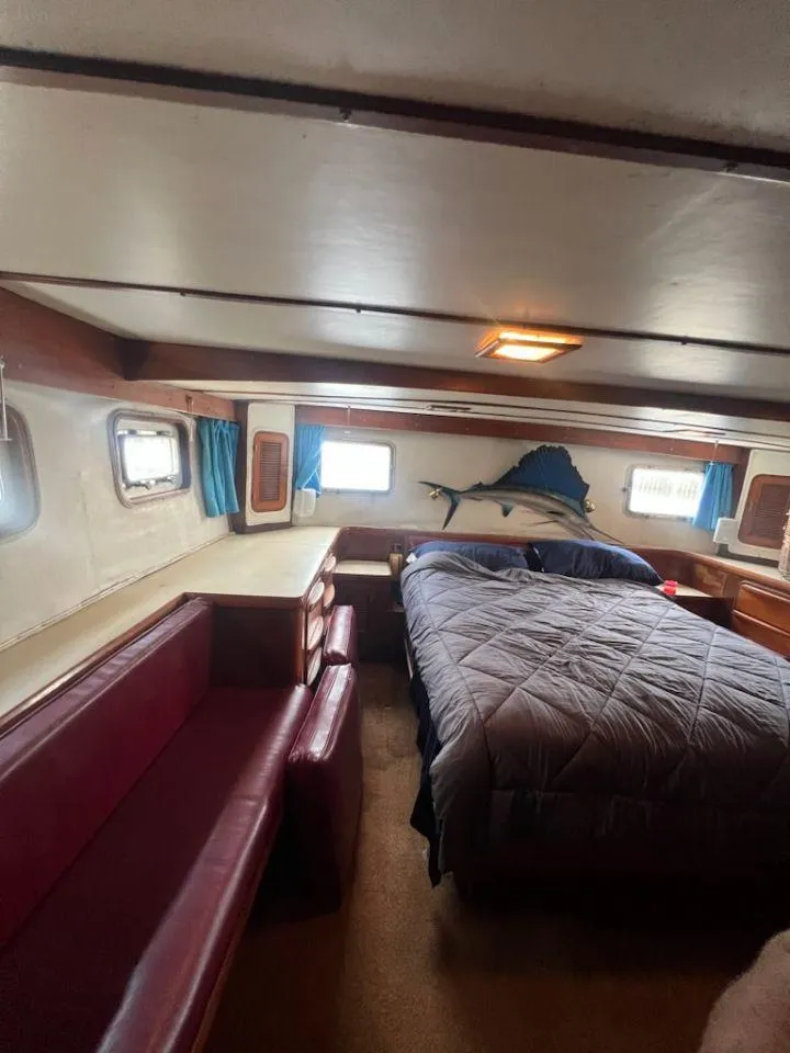 Slide: The Image of 1987 Marine Trader 62 Med Yacht bedroom with bed, seating, and wall-mounted fish decor. - 40
