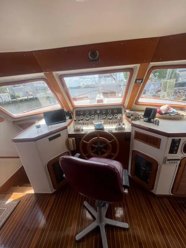 Slide: The Image of 1987 Marine Trader 62 Med Yacht helm station with panoramic windows and wooden steering wheel. - 8
