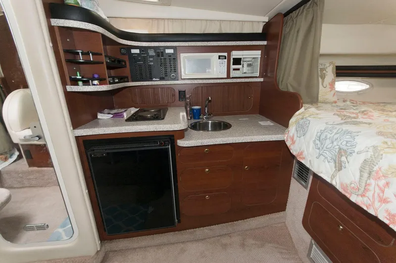 Slide: The Image of 2002 Rinker 342 Fiesta Vee cabin interior with kitchenette and bed. - 12