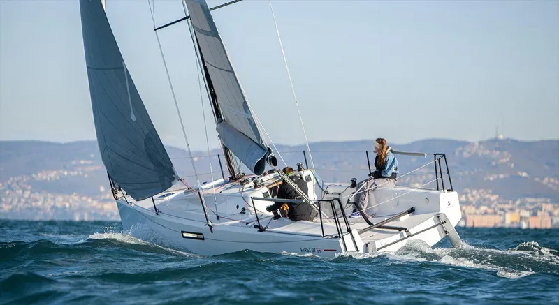 Slide: The Image of 2024 Beneteau First 27 sailboat navigating ocean waters with crew onboard. - 4