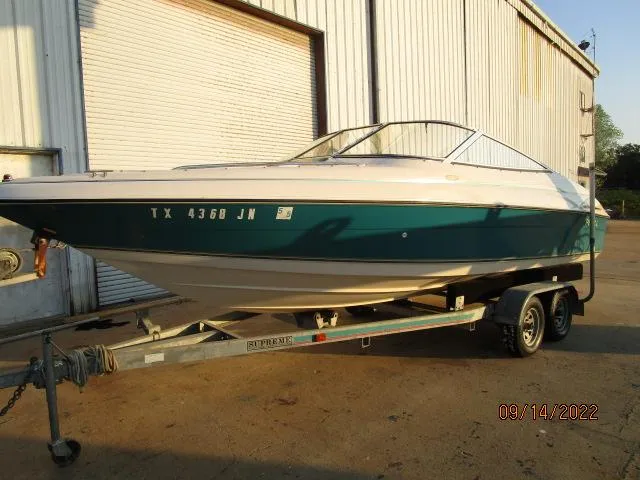 The Image of 1995 Regal VALANTI 222 SE boat on trailer, parked outside a warehouse. - 0