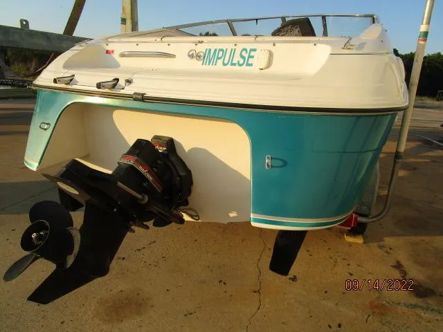 Slide: The Image of 1995 Regal VALANTI 222 SE boat, blue and white, with "IMPULSE" name, docked on land. - 3