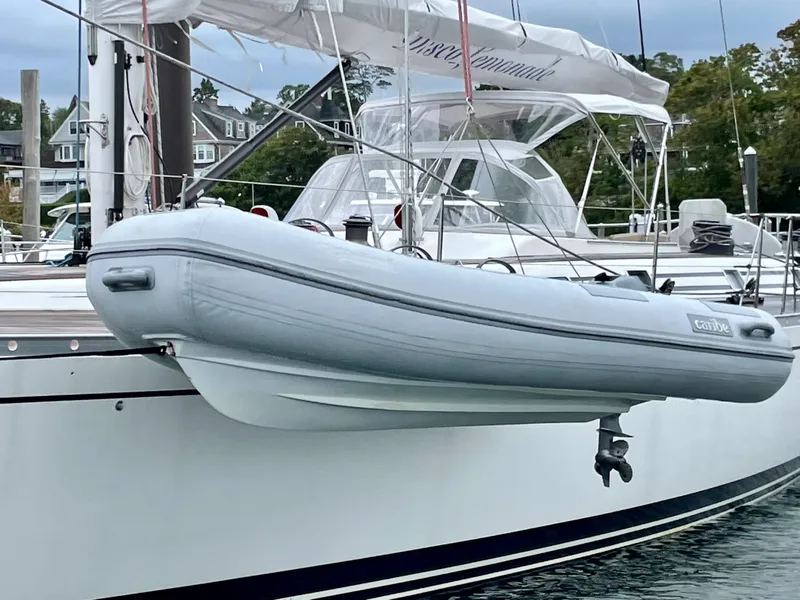 Slide: The Image of Nautor Swan 68 yacht from 1992 with a dinghy attached, docked at a marina. - 14