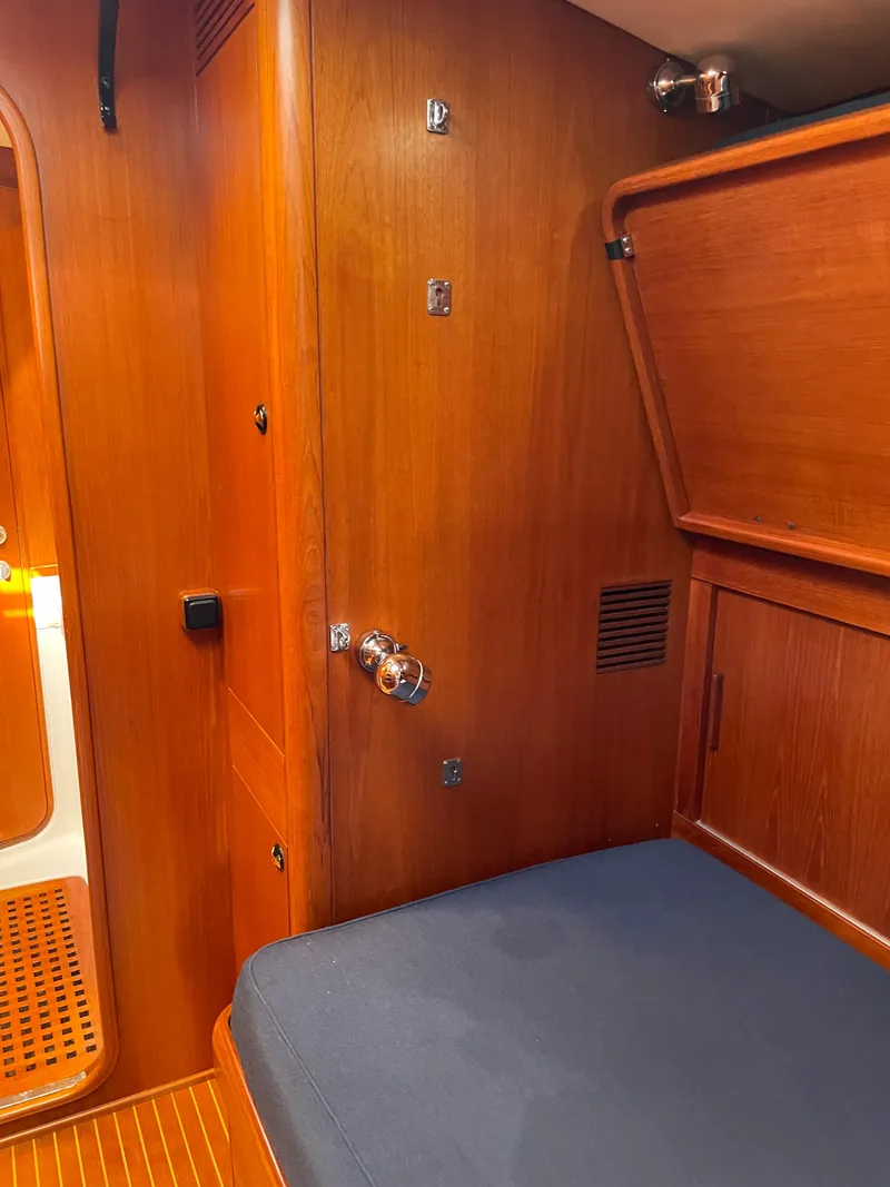Slide: The Image of Interior cabin of a 1992 Nautor Swan 68 yacht with wooden paneling and blue cushion. - 22