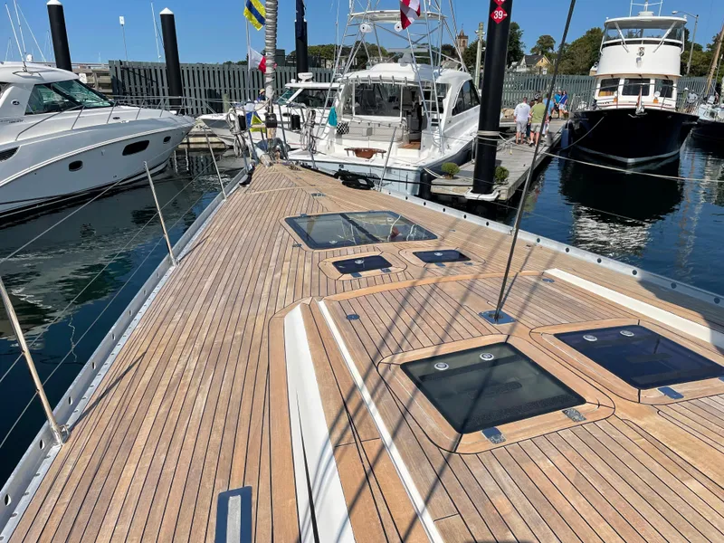 Slide: The Image of Nautor Swan 68 (1992) yacht deck with teak wood finish, docked at marina. - 6