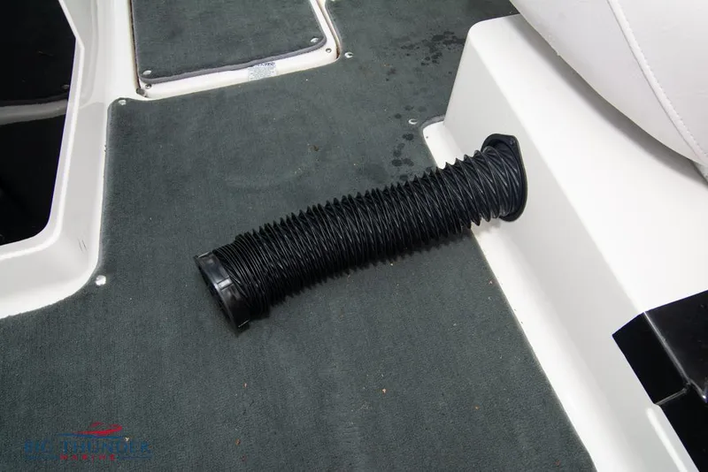 Slide: The Image of 2005 MasterCraft X45 interior with black flexible hose on grey carpet. - 38