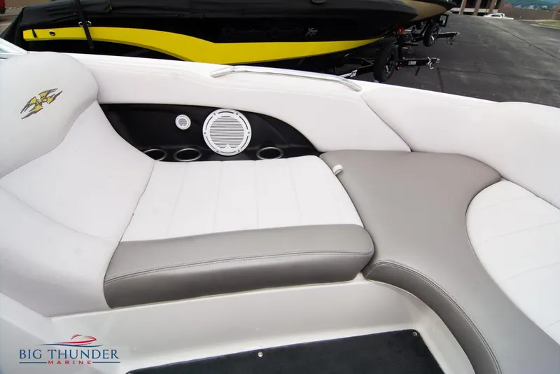 Slide: The Image of 2005 MasterCraft X45 boat interior with white and gray seating, speaker, and cup holders. - 46