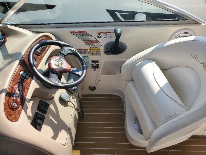 Slide: The Image of 2003 Sea Ray 260 Sundancer helm with steering wheel and captain's seat. - 12