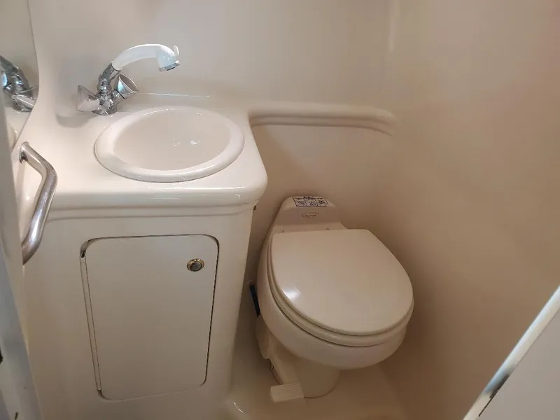 Slide: The Image of Compact bathroom in 2003 Sea Ray 260 Sundancer boat with sink and toilet. - 2