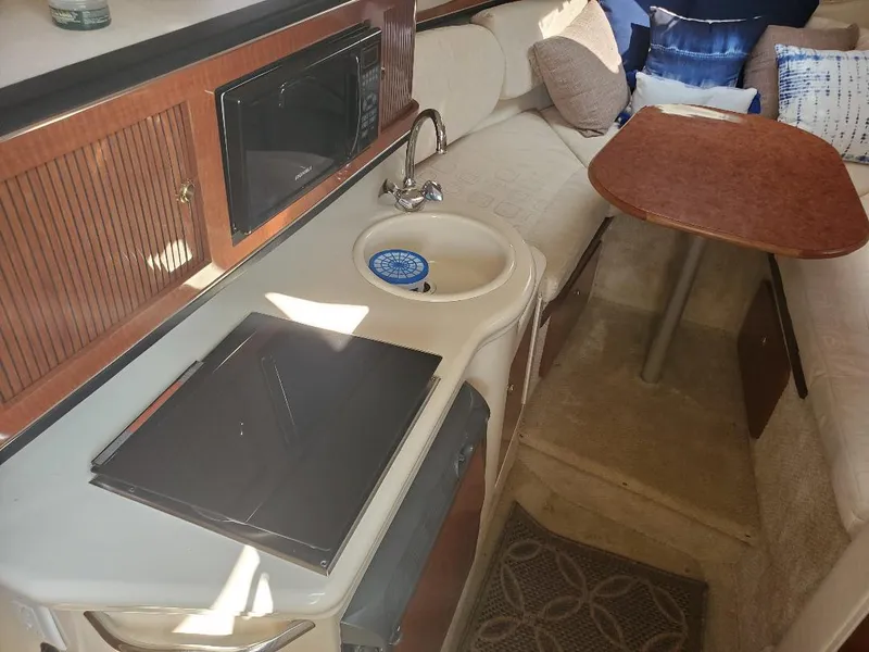 Slide: The Image of Interior of 2003 Sea Ray 260 Sundancer with kitchenette, sink, and seating area. - 8