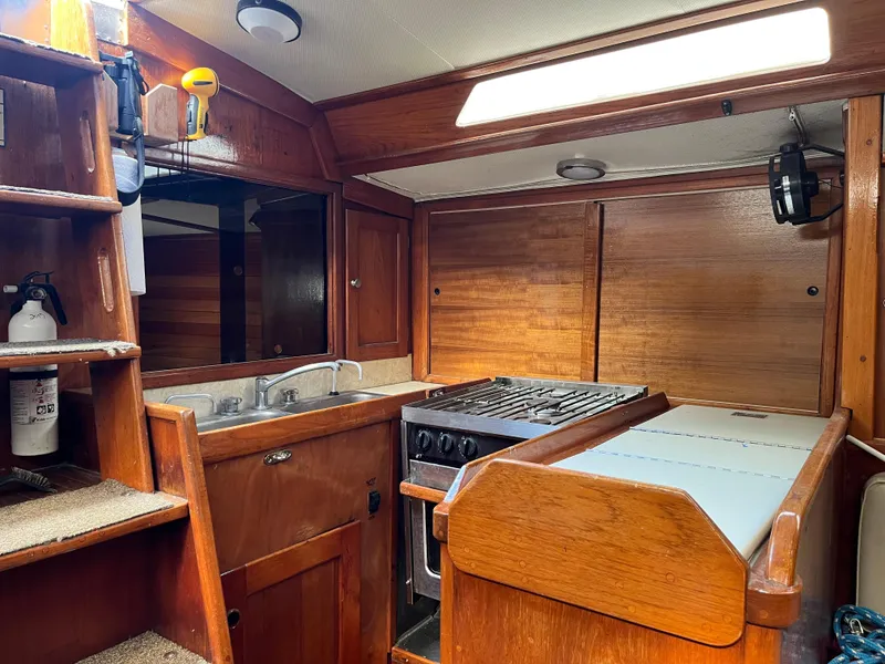 Slide: The Image of 1978 Palmer Johnson New York 40 Sloop interior with wooden cabinetry and compact kitchen. - 2