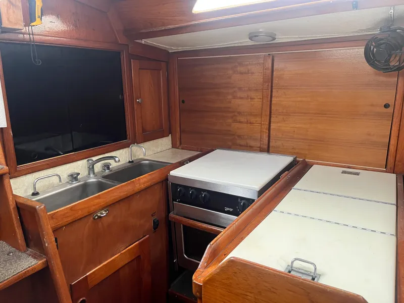 Slide: The Image of 1978 Palmer Johnson New York 40 Sloop kitchen with wooden cabinetry and dual sink. - 3