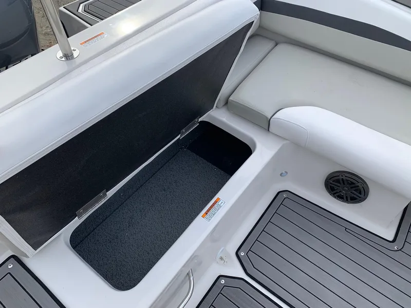 Slide: The Image of 2026 Starcraft SVX 190 boat interior with open storage compartment and cushioned seating. - 16
