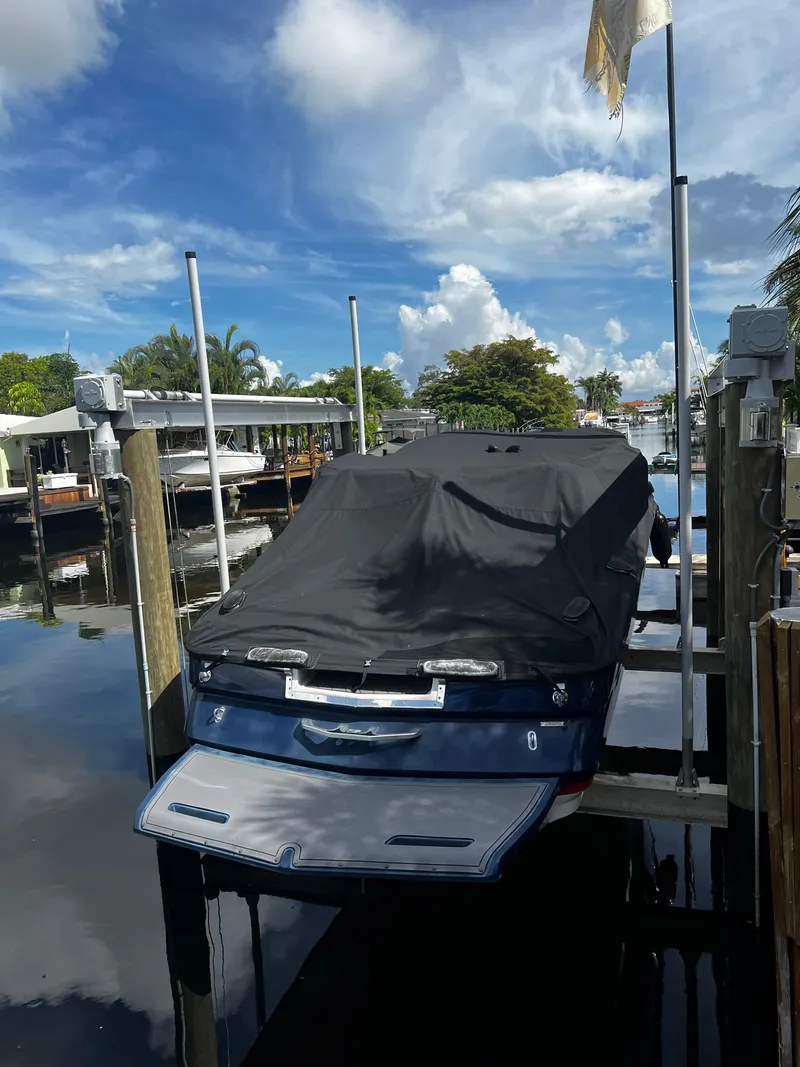 Slide: The Image of 2014 MasterCraft X-55 boat docked with cover on, under a clear blue sky. - 0