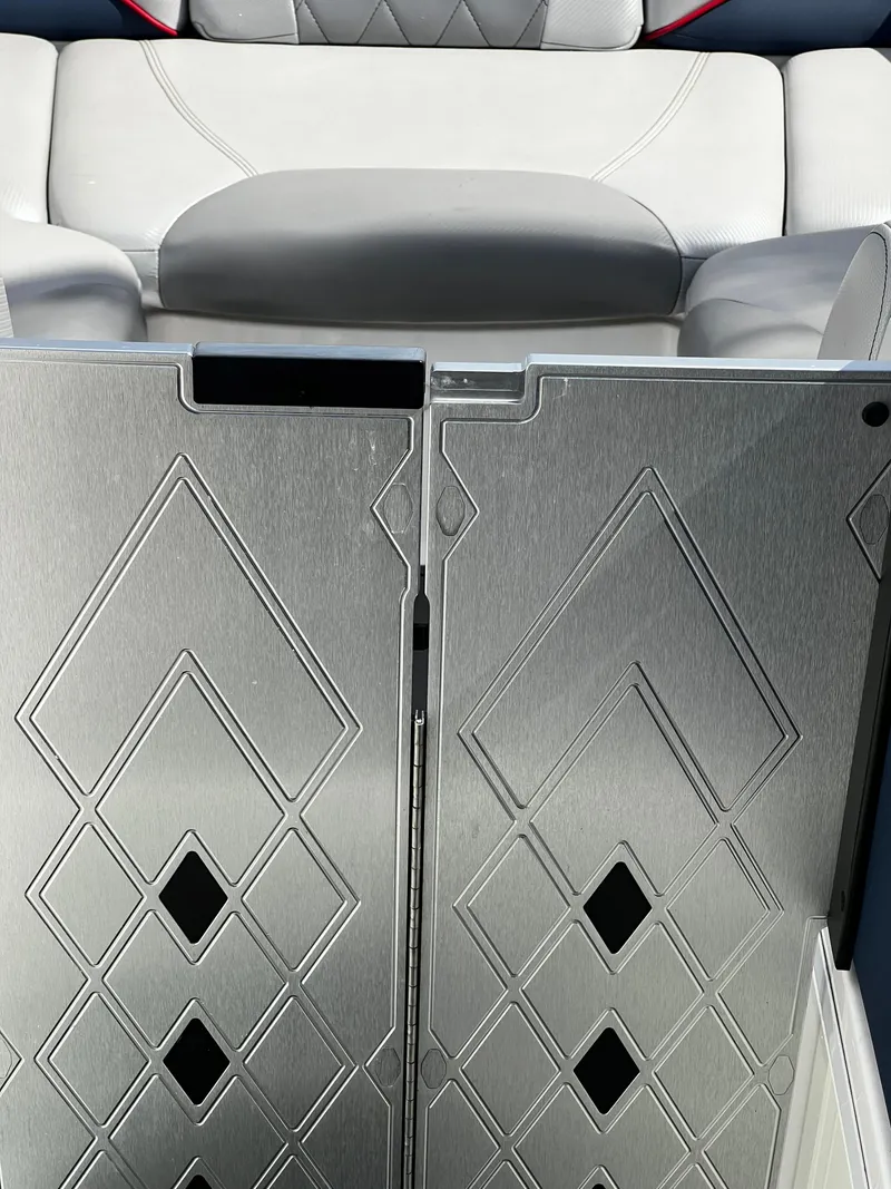 Slide: The Image of 2014 MasterCraft X-55 boat interior with diamond-patterned metal door and cushioned seating. - 14