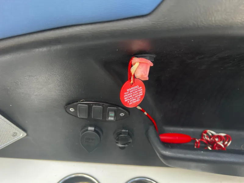 Slide: The Image of MasterCraft X-55 2014 boat dashboard with safety lanyard and switches. - 28
