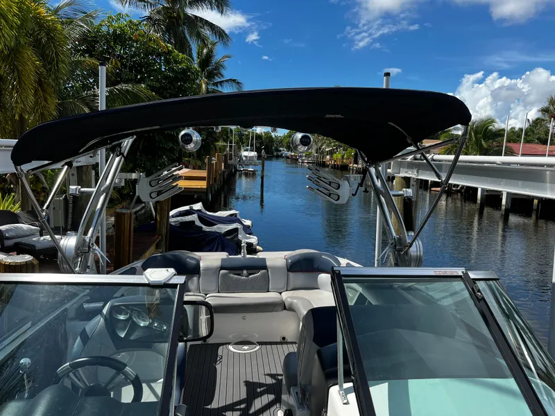 Slide: The Image of 2014 MasterCraft X-55 boat docked in a tropical canal setting. - 35