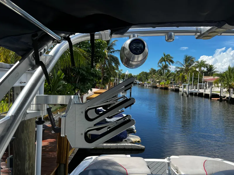 Slide: The Image of 2014 MasterCraft X-55 boat docked on a sunny canal with palm trees. - 36
