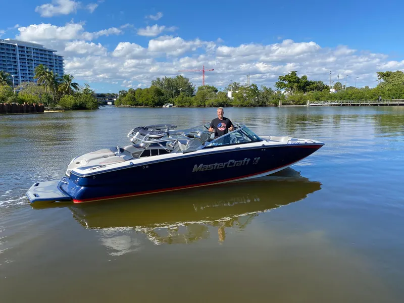 Slide: The Image of 2014 MasterCraft X-55 boat on a calm river with a person onboard. - 47