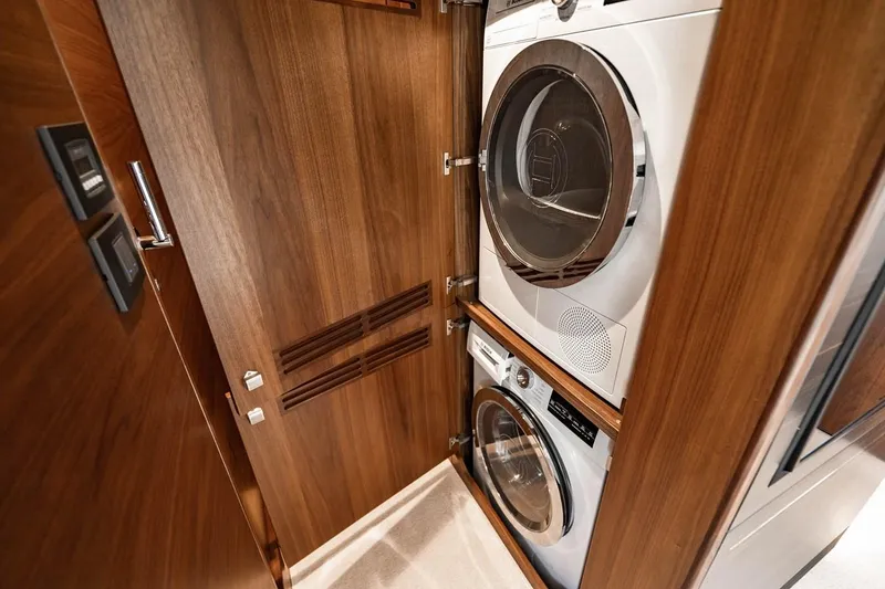 Slide: The Image of A sleek laundry area with wood paneling and modern washing machines aboard a yacht. - 27