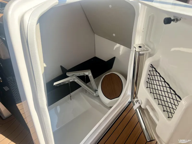 Slide: The Image of 2025 Yamaha Boats 252SE interior storage compartment with wooden accents and netted pocket. - 5