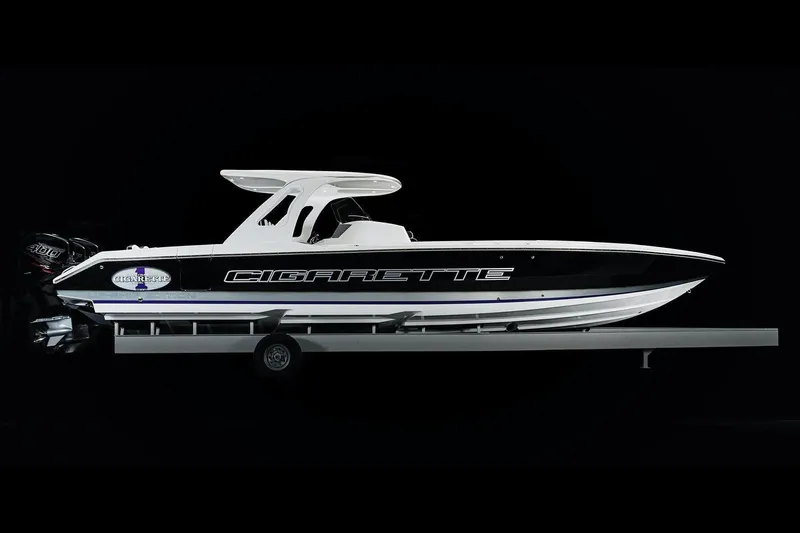 Slide: The Image of 2025 Cigarette 39 GTS speedboat on trailer, side view, black and white design. - 3