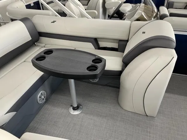 Slide: The Image of 2023 Starcraft EX 22 Q boat interior with cushioned seating and a table. - 14