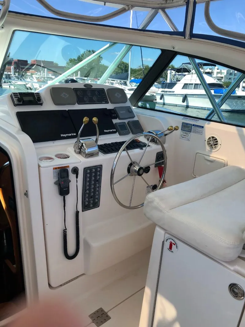 Slide: The Image of 2006 Tiara Yachts 3800 Open helm with steering wheel and controls, docked at marina. - 11