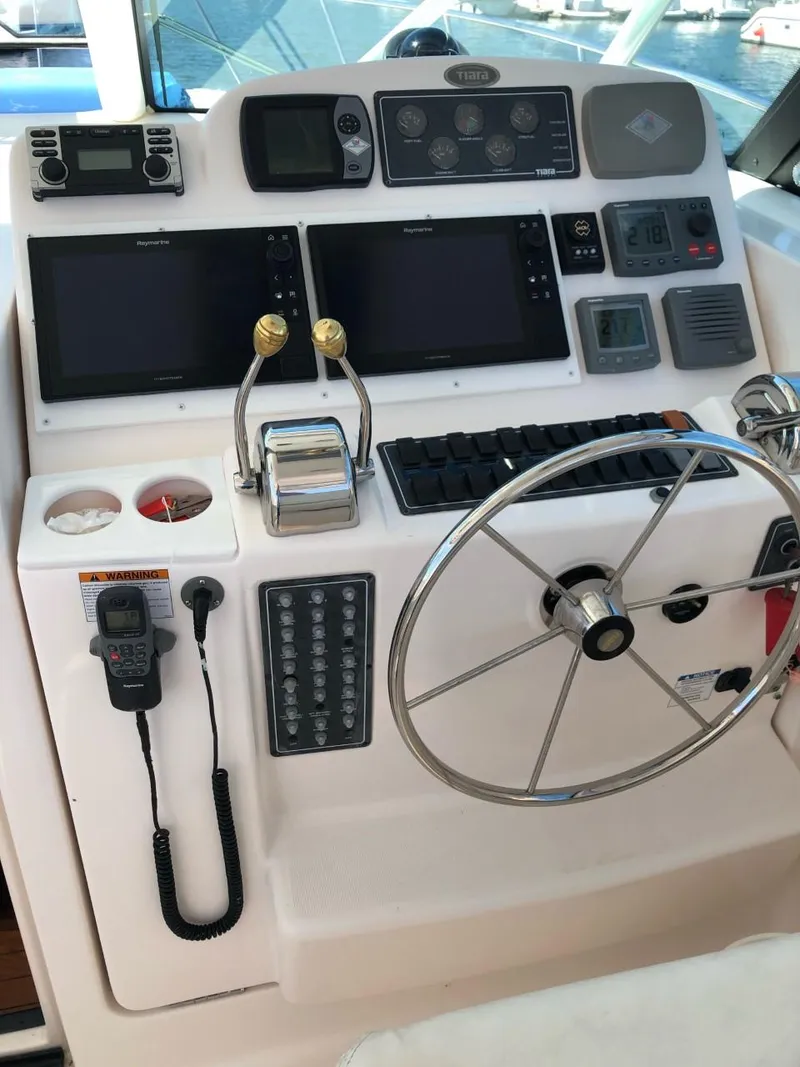 Slide: The Image of Helm of 2006 Tiara Yachts 3800 Open with navigation controls and steering wheel. - 12