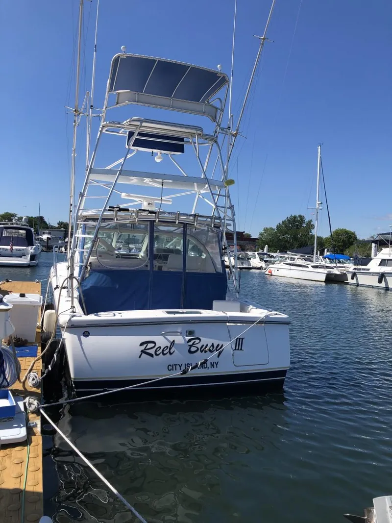 Slide: The Image of 2006 Tiara Yachts 3800 Open docked, featuring a tower and blue accents. - 2
