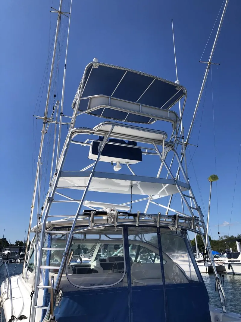 Slide: The Image of 2006 Tiara Yachts 3800 Open with tower, docked under clear blue sky. - 4