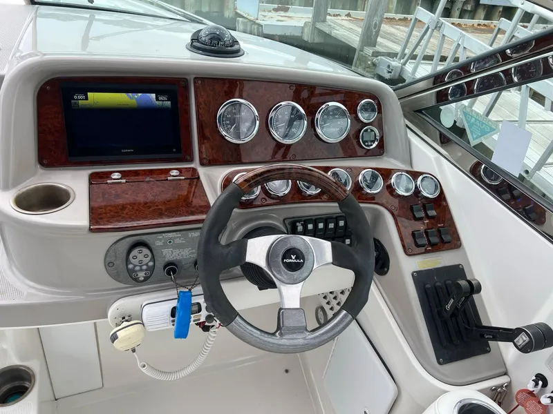 Slide: The Image of 2003 Formula 330 Sun Sport dashboard with steering wheel, gauges, and navigation screen. - 10