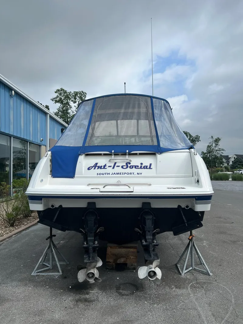 Slide: The Image of 2003 Formula 330 Sun Sport boat on stands, rear view, with blue cover. - 2