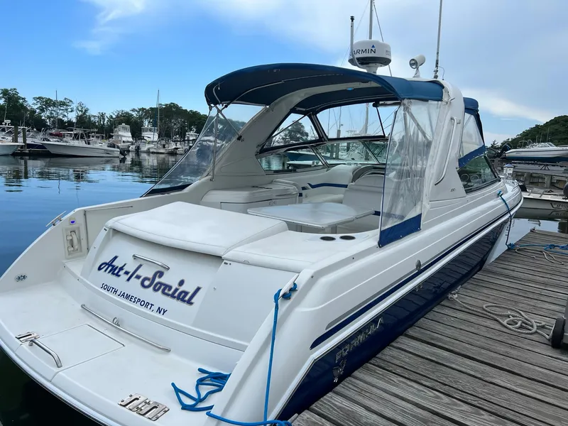 Slide: The Image of 2003 Formula 330 Sun Sport boat docked, featuring blue and white design, named "Anti-Social." - 3