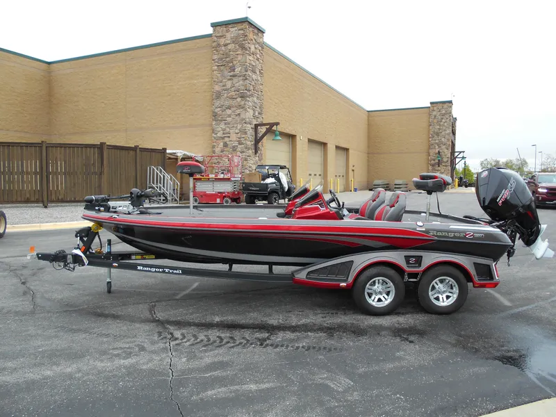 Slide: The Image of 2023 Ranger Z520R bass boat on trailer, parked outside a commercial building. - 2