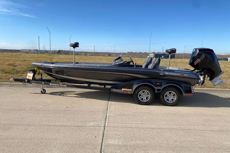 The Image of 2023 Ranger Z520R bass boat on trailer, parked on concrete with clear blue sky. - 0