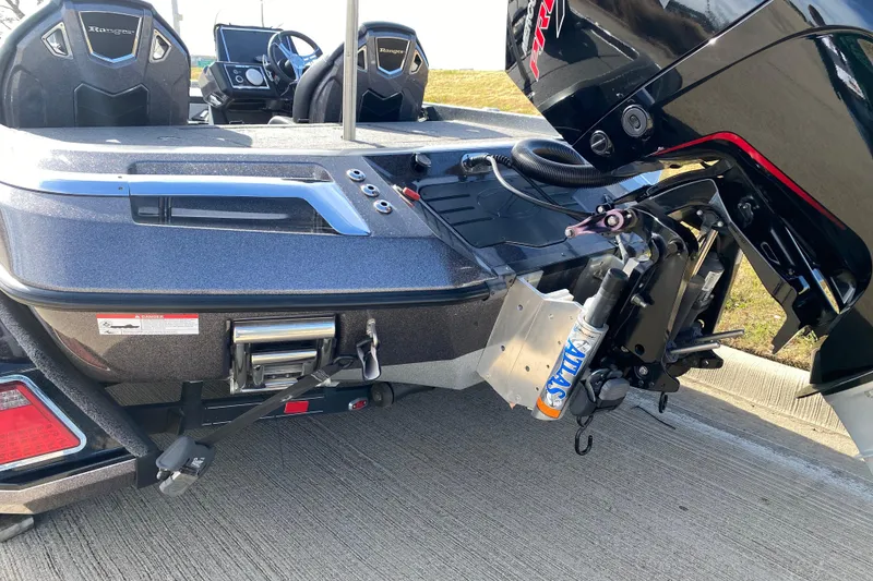 Slide: The Image of 2023 Ranger Z520R boat with motor and seating, parked on concrete surface. - 12