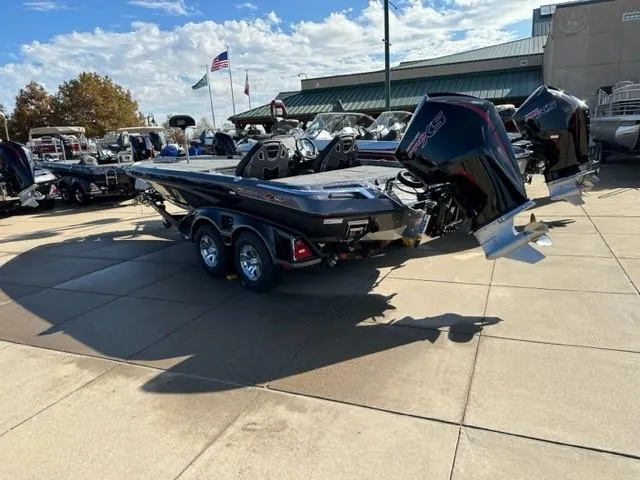 Slide: The Image of 2023 Ranger Z520R bass boat on trailer, parked on a concrete surface under a clear blue sky. - 2