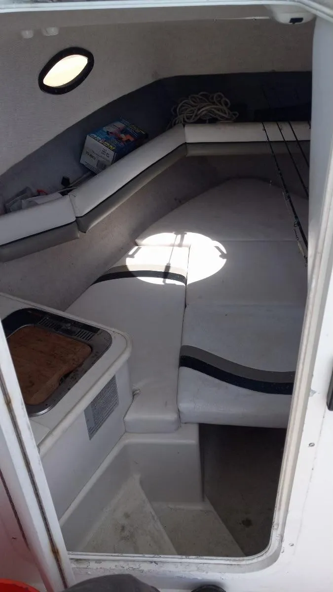 Slide: The Image of 2001 Seaswirl Striper 2600 Sport Cabin interior with seating and storage. - 11