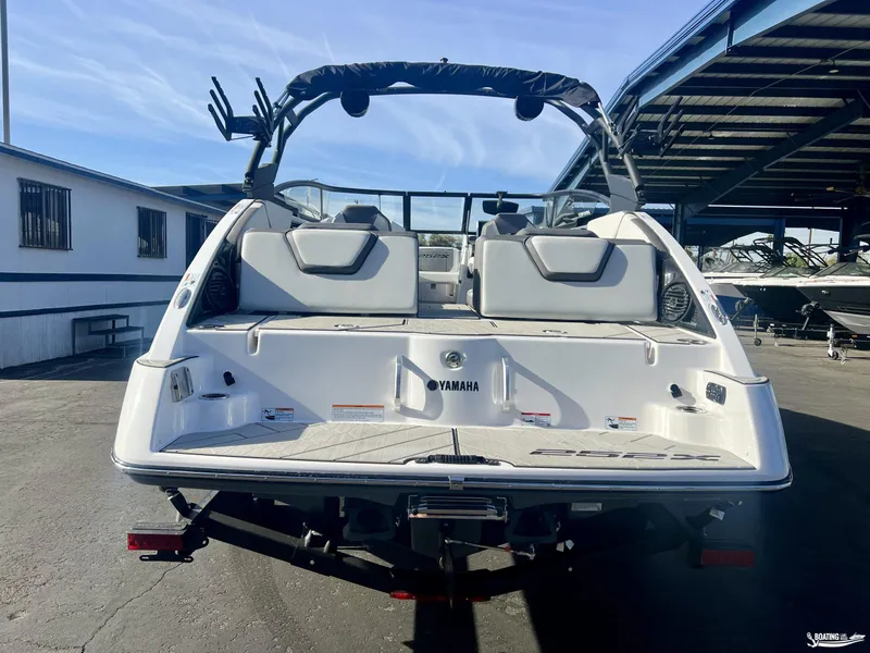 Slide: The Image of 2025 Yamaha Boats 252XE, rear view, parked in a marina. - 2