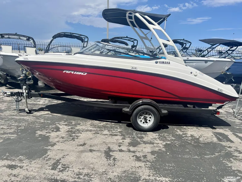 Slide: The Image of 2024 Yamaha AR190 boat in vibrant red on a trailer, displayed outdoors. - 0