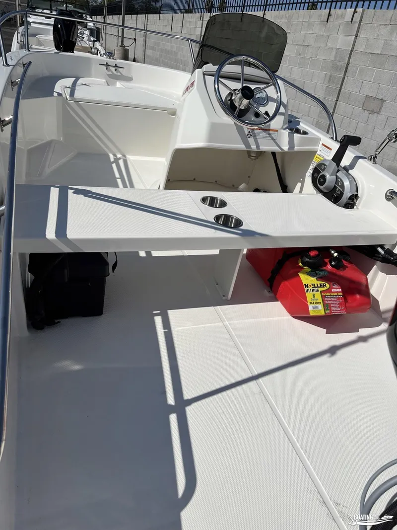 Slide: The Image of 2024 Boston Whaler 130 Super Sport boat interior with steering console and seating. - 2