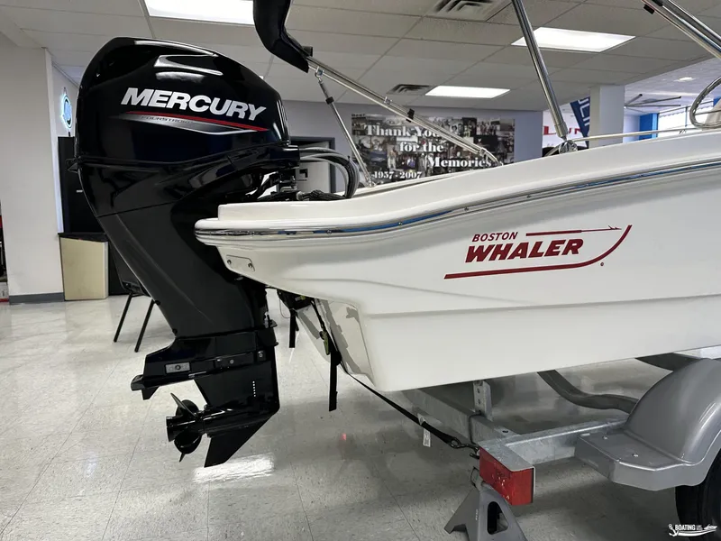 Slide: The Image of 2024 Boston Whaler 130 Super Sport with Mercury outboard motor in showroom. - 6
